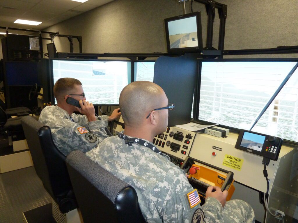 two men in camo working on a computer