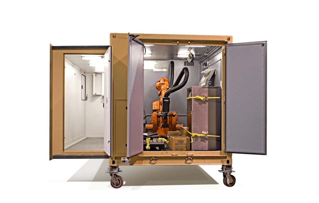 A robotic arm is enclosed within a mobile, open-sided cubical structure with insulating panels.