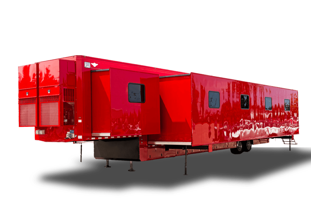 A large, bright red trailer with multiple windows and an extended section is pictured.