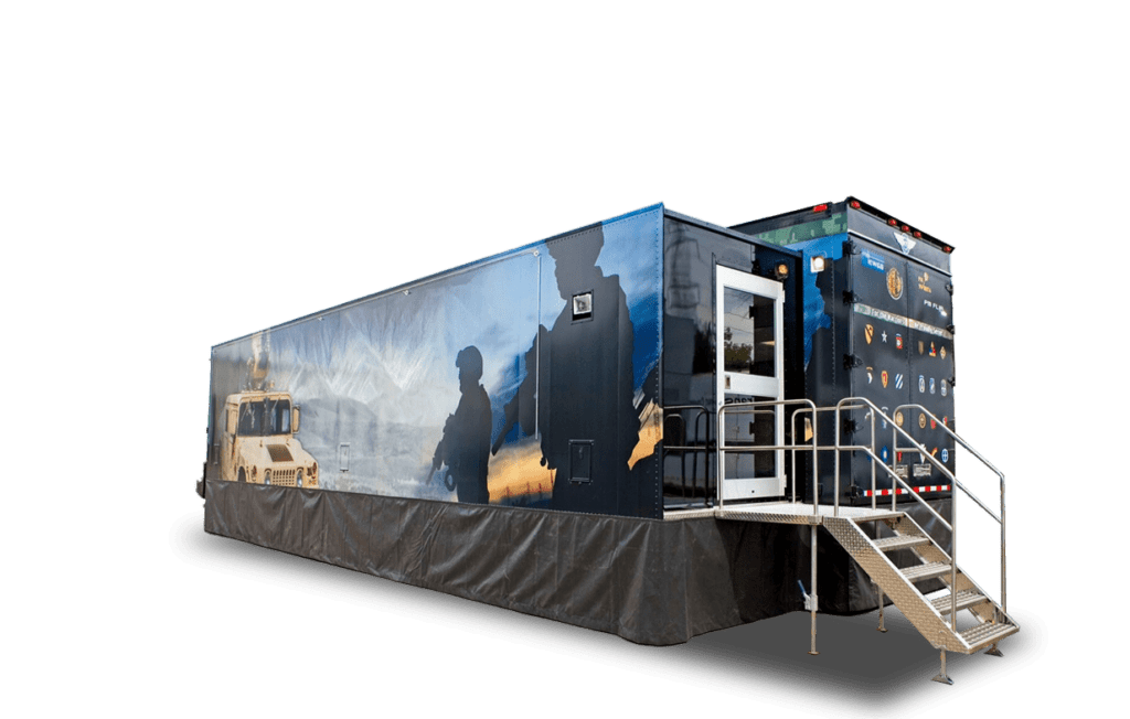 A large, black mobile structure features images of people and nature on its side, with a staircase leading up to an entrance.